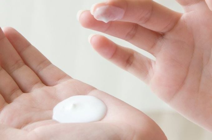 person with body lotion in their hand