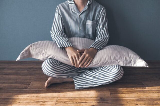 woman wearing eco-friendly pajamas - holding a pillow
