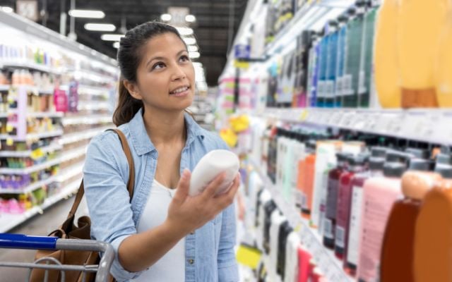 woman shopping for shampoo in a drugstore