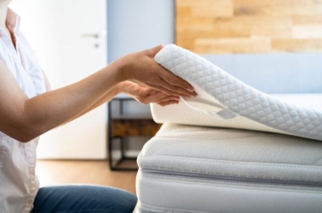 woman placing a Mattress topper onto a mattress