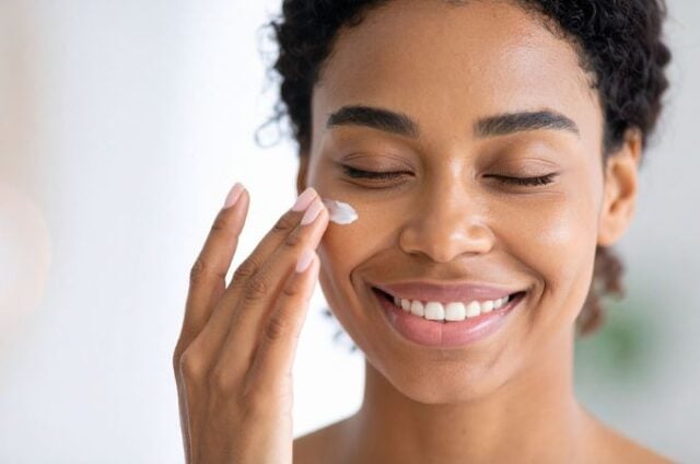 woman applying face moisturizer