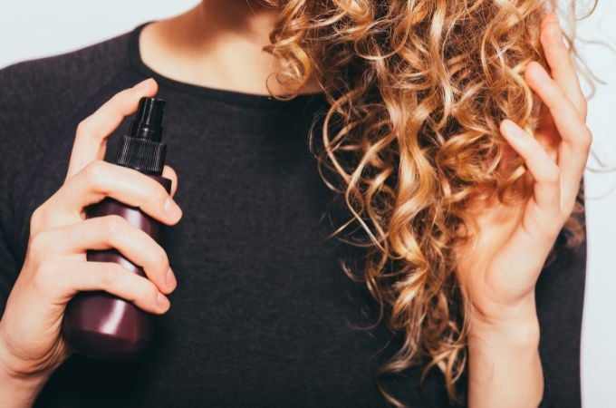 woman spraying her curly hair
